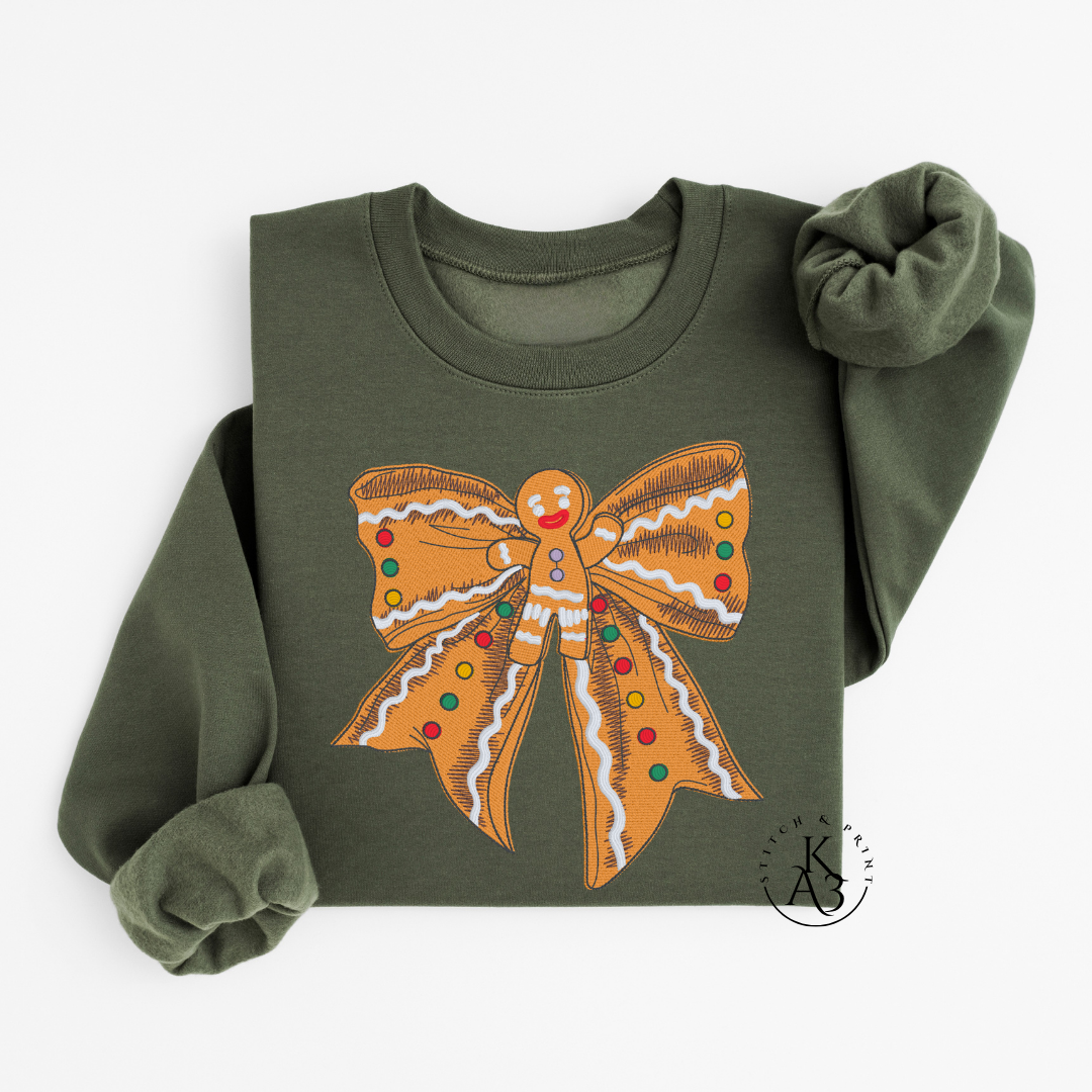 Green sweatshirt with an embroidered gingerbread bow design on a white background