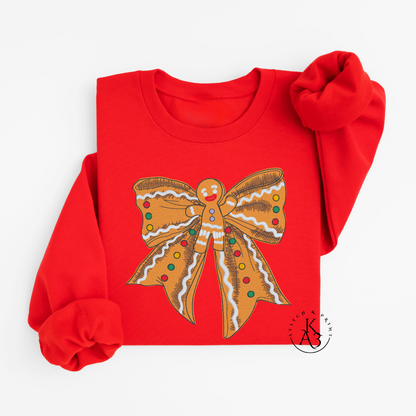 Red sweatshirt with an embroidered gingerbread-themed bow design on a white background