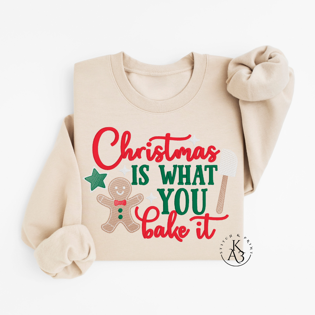 Beige sweatshirt with Christmas-themed text and gingerbread man graphic on a white background