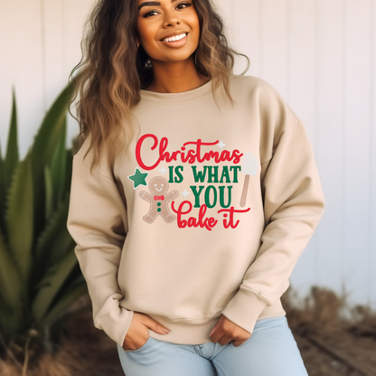 Woman wearing a beige sweatshirt with Christmas-themed text and graphics.