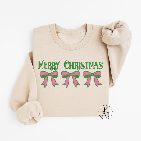 Beige sweatshirt with an embroidered 'Merry Christmas' text and pink bows on a white background