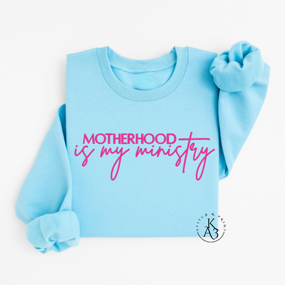 Personalized Sky Blue sweatshirt with pink text embroidered "Motherhood is my ministry"
