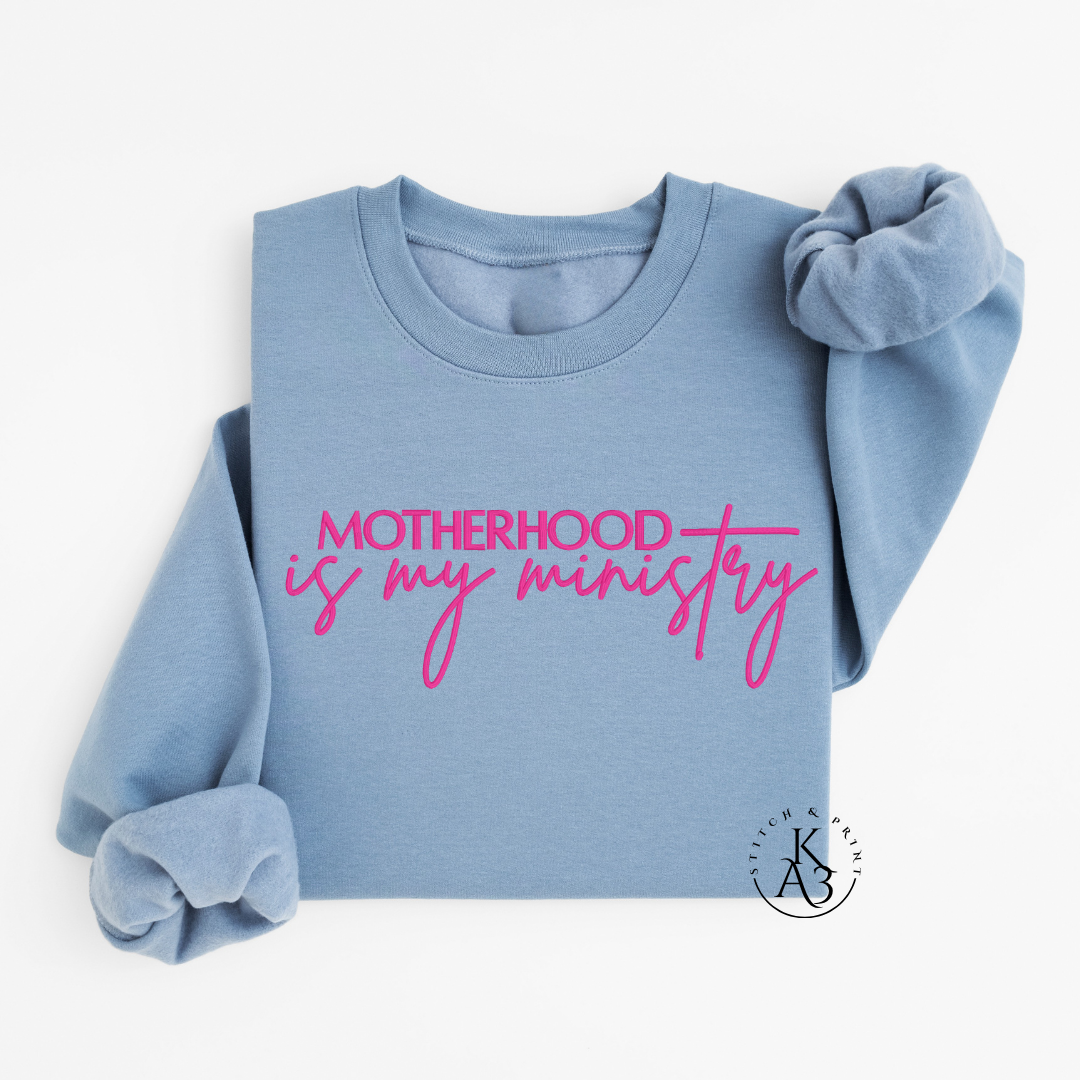 Personalized Stone Blue sweatshirt with pink text embroidered "Motherhood is my ministry"